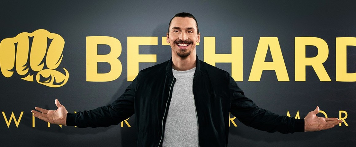 Fotbollsspelaren Zlatan Ibrahimović med armarna öppna framför Bethard logotypen